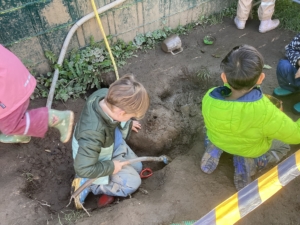 Kinder spielen in einer Matschkuhle