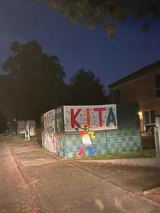 Banner "Kita" hängt am Zaun der Kita und wird angeleuchtet