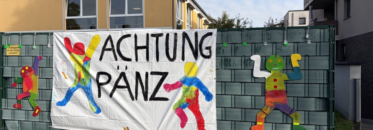 Ein Banner mit der Aufschrift Achtung Pänz hängt am Zaun