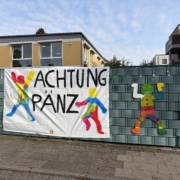 Ein Banner mit der Aufschrift Achtung Pänz hängt am Zaun