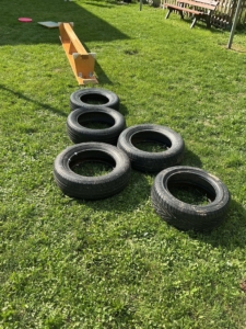 Ein Parcour aus Reifen und einer umgedrehten Bank auf der Wiese