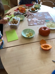 Kinder schneiden Kartoffeln und Kürbisse klein